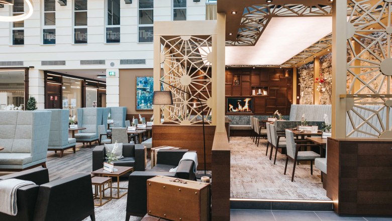 Interior view of a modern caf&eacute; with cozy seating areas, fireplace and stylish decoration.