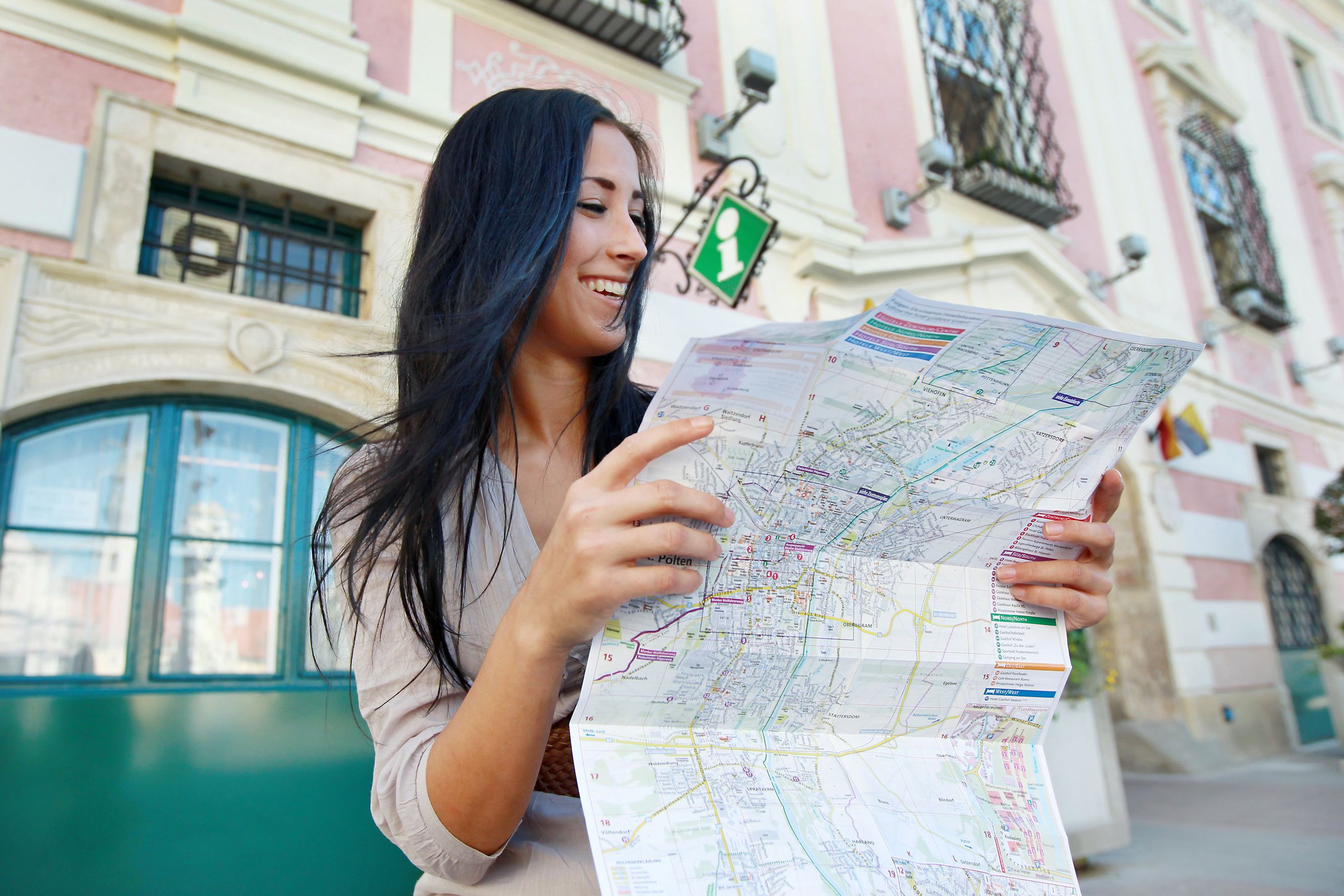 Woman with a map in front of the St. Pölten tourist office.