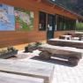 Wooden benches in front of a building with maps on the wall.