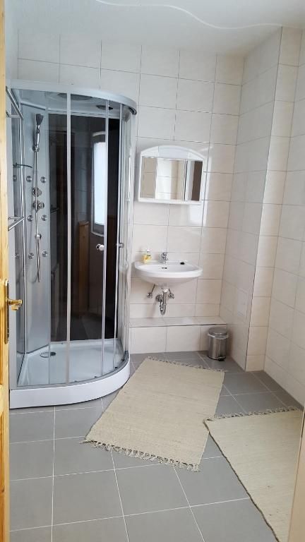 Modern bathroom with shower, washbasin and mirror.