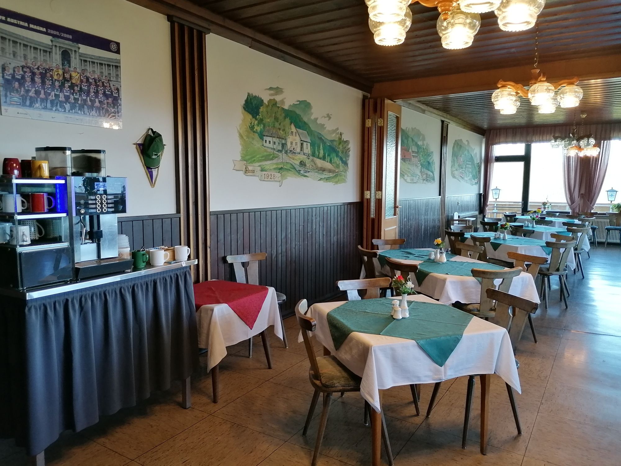 Interior view of a restaurant with wooden furniture and tablecloths.