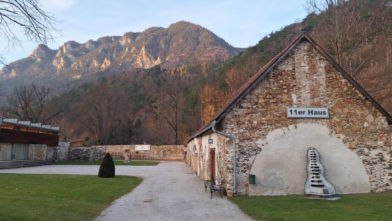 Exterior view of the 11er Haus with mountain scenery in the background.
