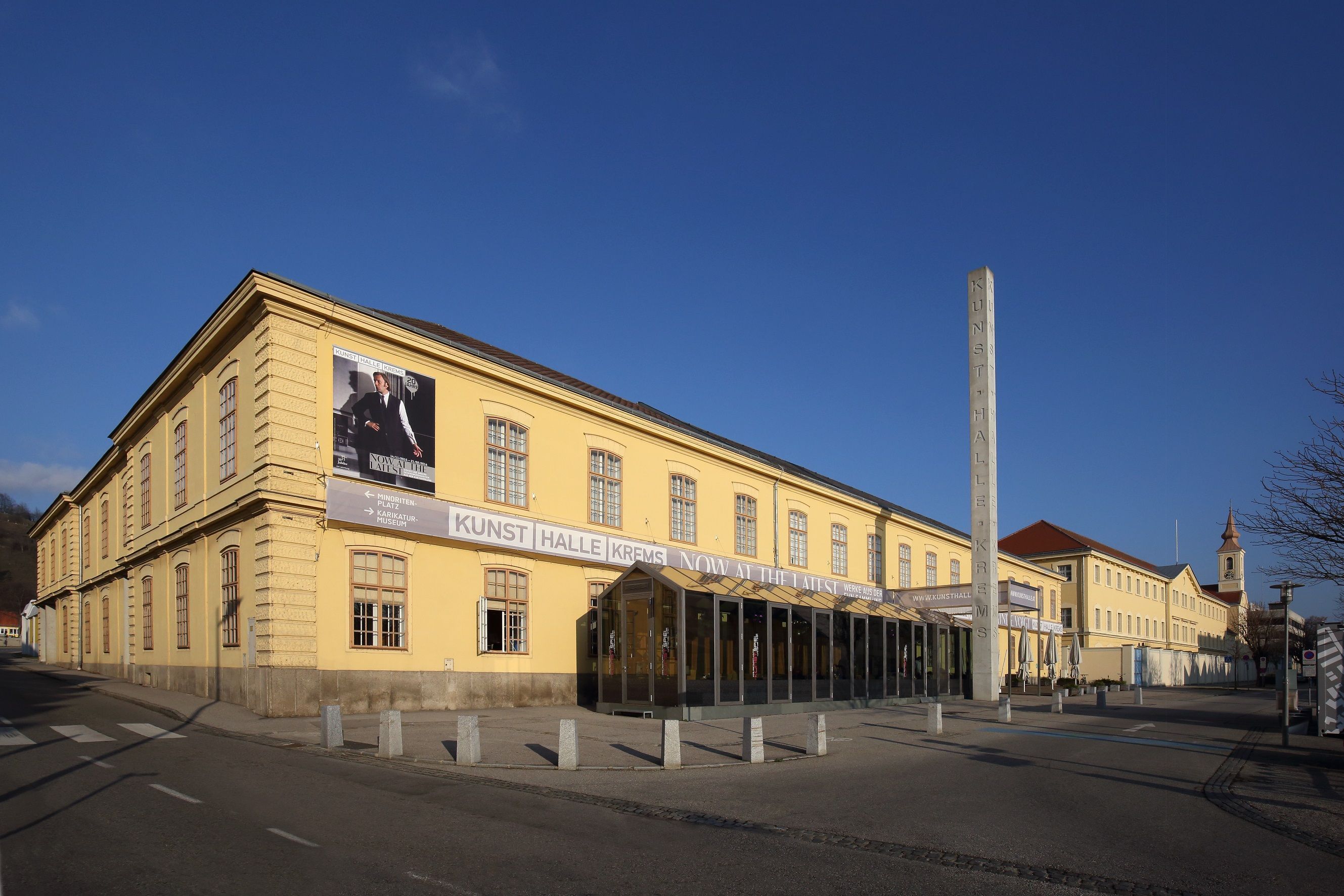 Exterior view of the Kunsthalle Krems with yellow building and blue sky.