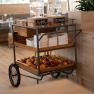 Breakfast area with a trolley full of fruit and drinks dispensers.