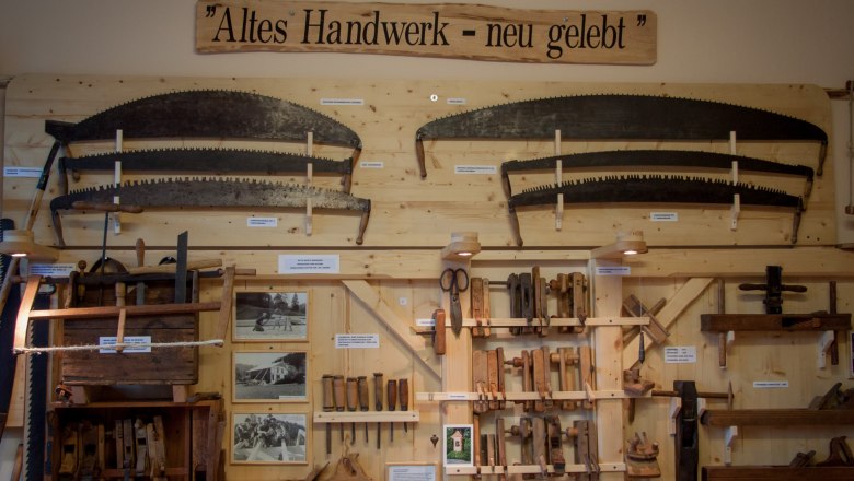Exhibition of old hand tools on a wooden wall with the sign 'Old craft - new life'.