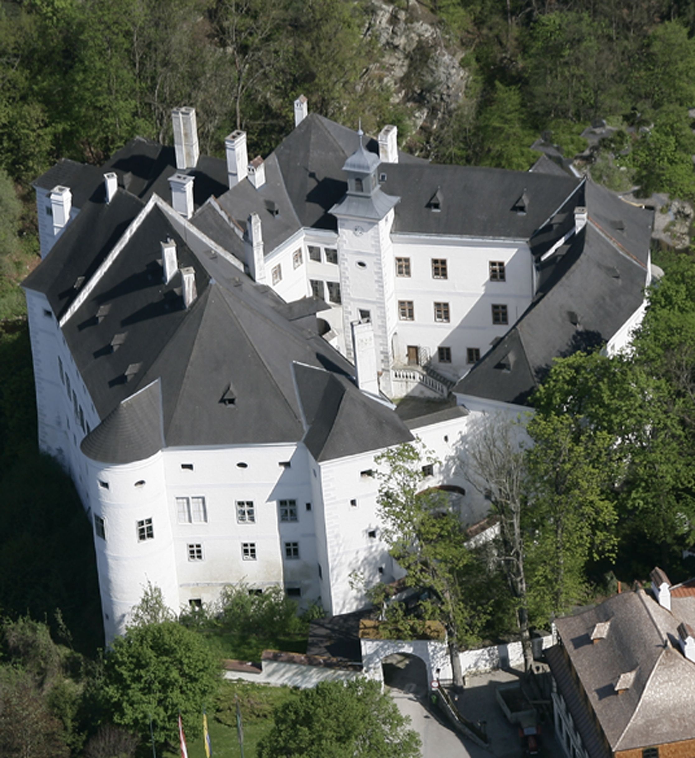 Aerial view of the Europaschloss Leiben surrounded by trees.