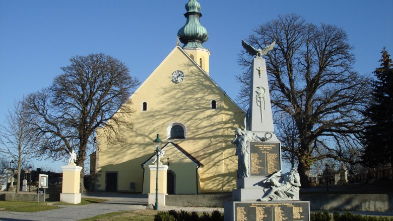 Parish church of St. Hippolytus with war memorial in the foreground.