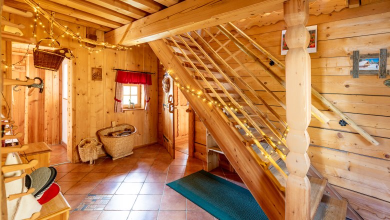 Room with wood paneling, tiled floor, a staircase and decoration.