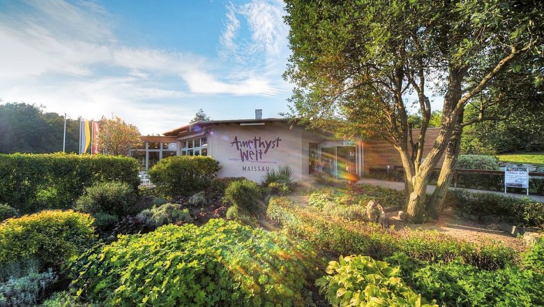 Entrance to Amethyst Welt Maissau with garden and trees in the foreground.