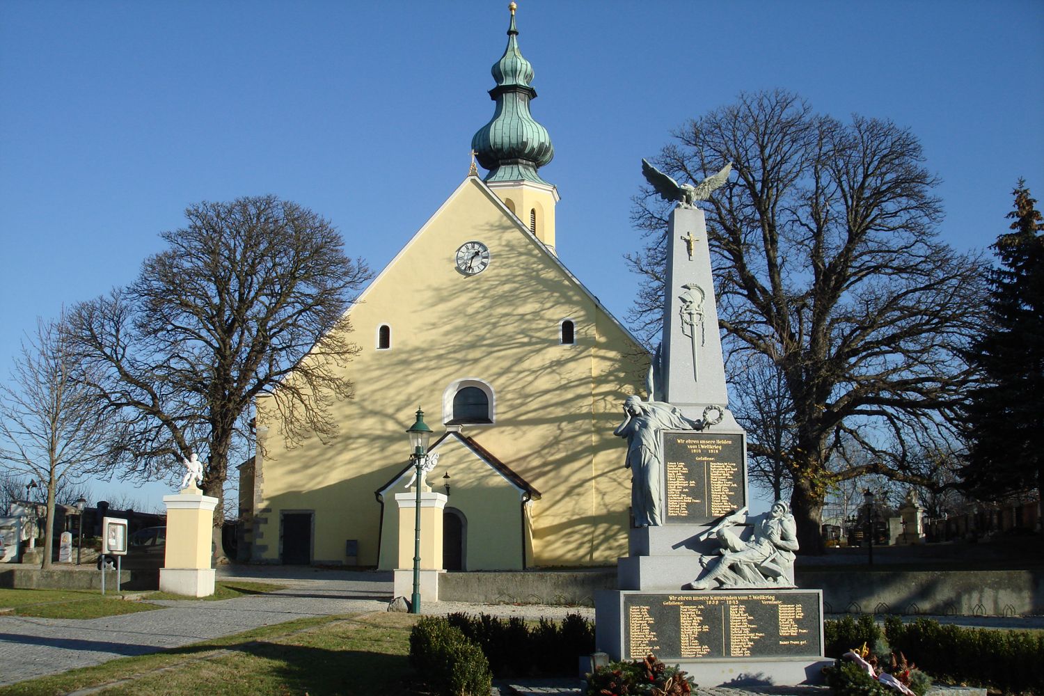 Parish church of St. Hippolytus with war memorial in the foreground.