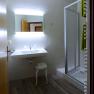 Modern bathroom with washbasin, illuminated mirror and shower.