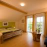 Comfortable bedroom with double bed, wooden furniture and balcony access.
