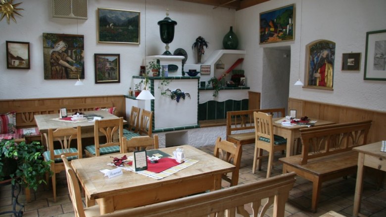 Cozy dining room with wooden furniture and decorative paintings on the walls.