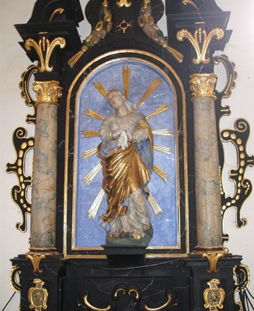 Baroque sculpture of the Madonna of Sorrows in a richly decorated altar.
