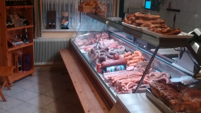Butcher's shop with meat and sausage products in a sales counter.