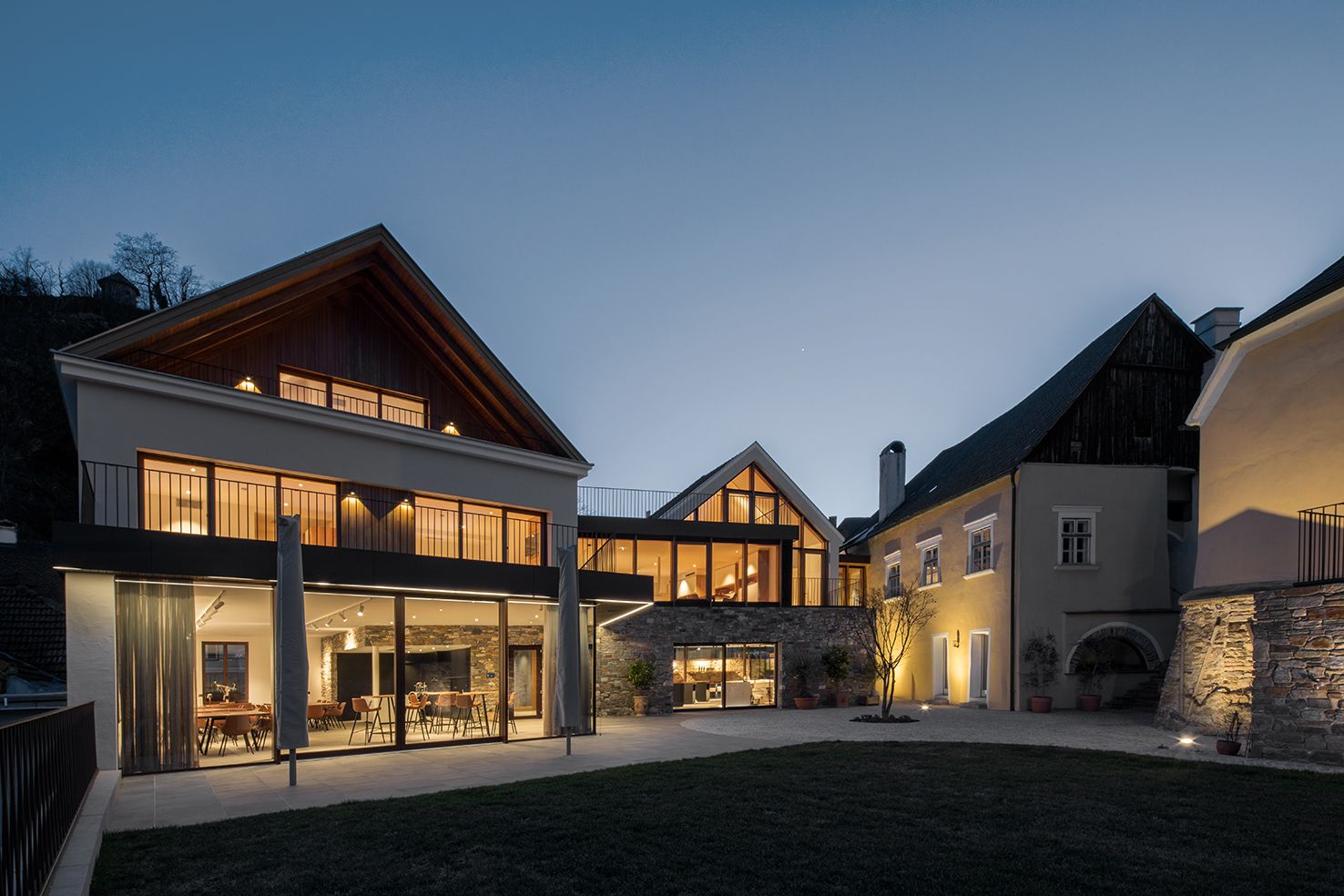 Modern building of the Mauritiushof with large windows at dusk, illuminated by warm light.