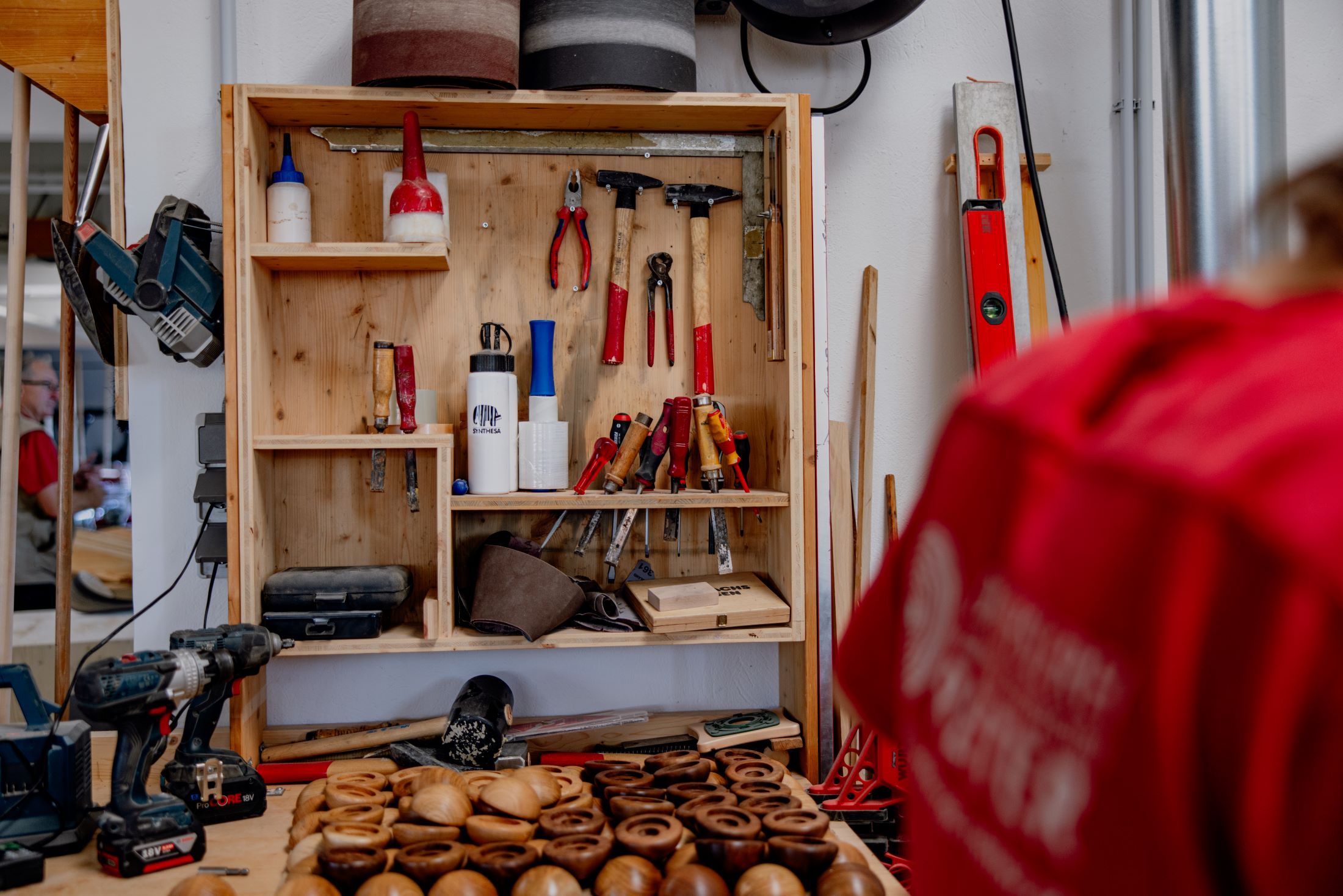 Workshop with tools and woodwork on a table.