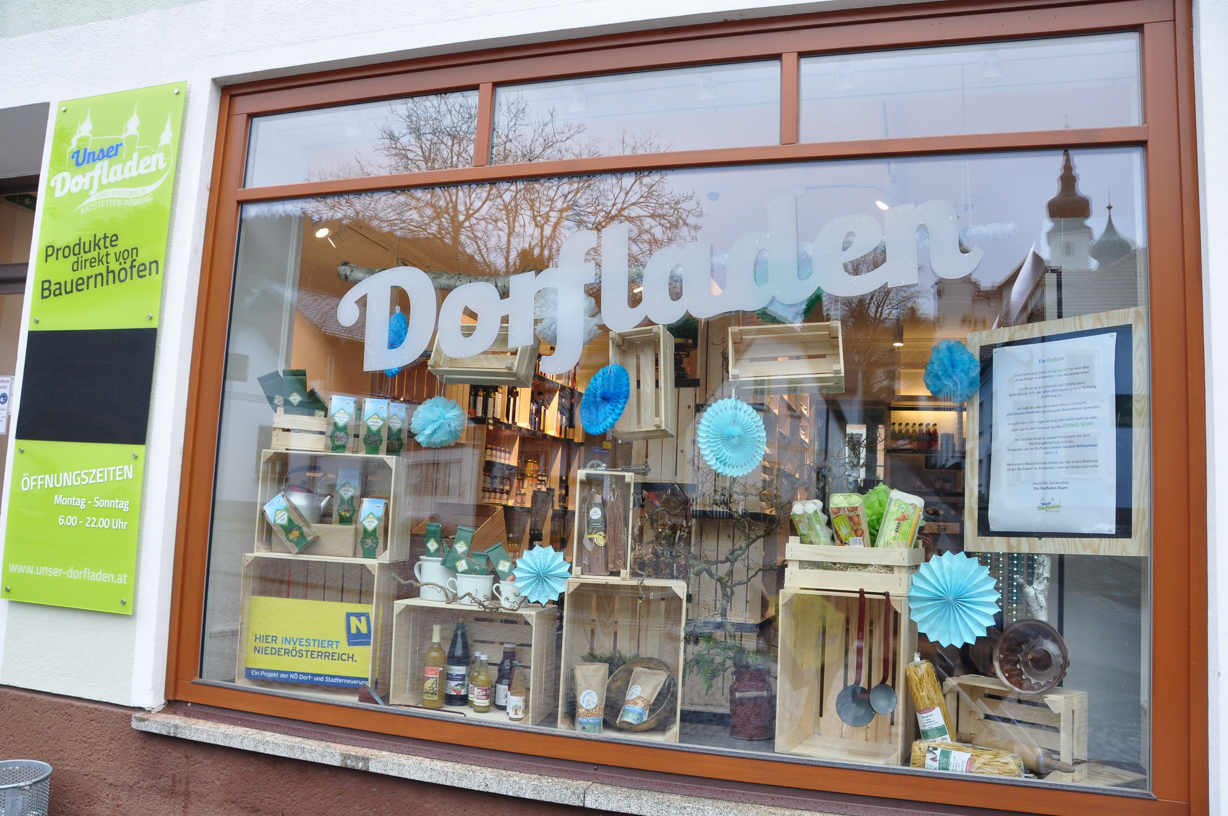 Shop window of a village store with products and decorations.