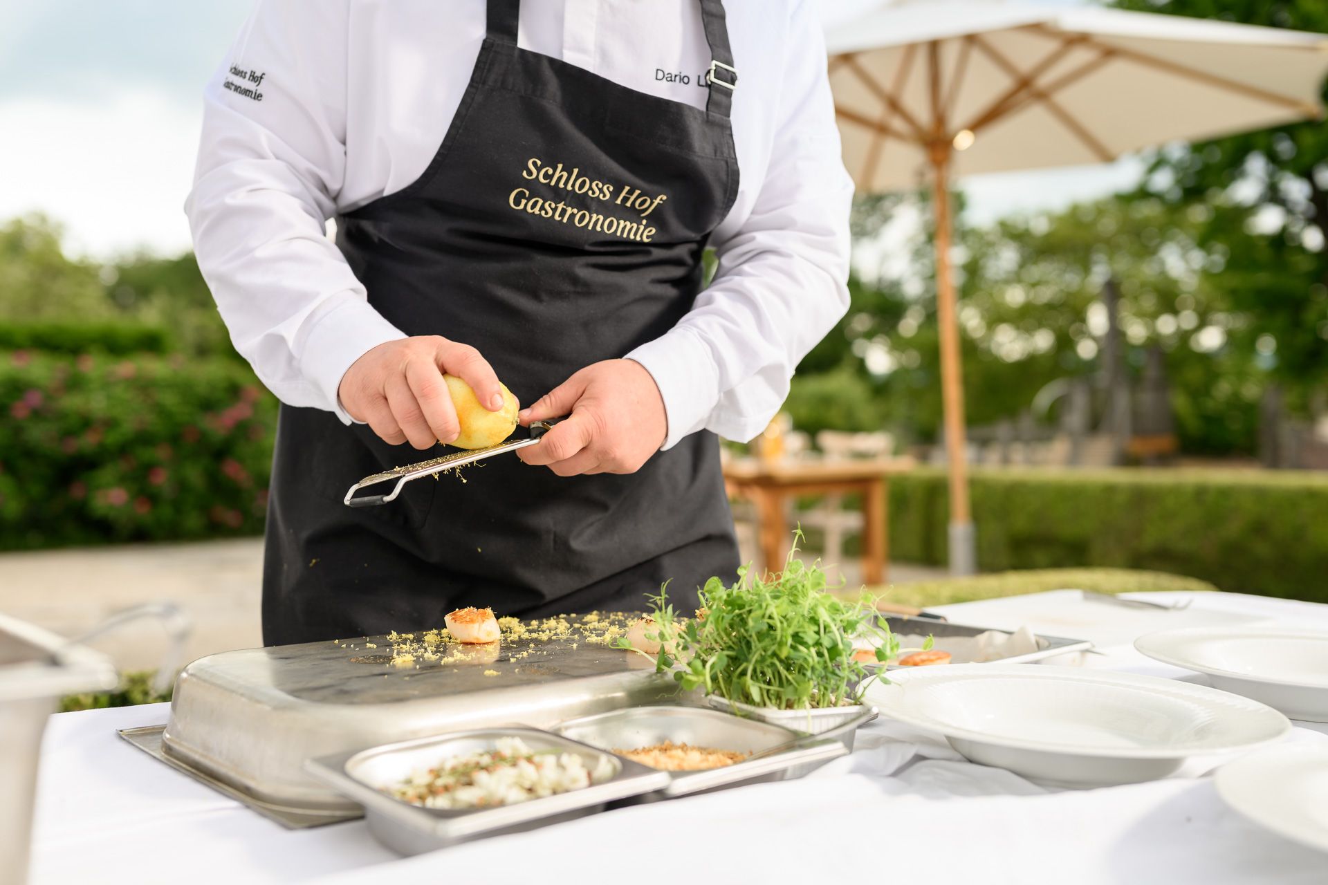 Chef rubs a fresh lemon over a prawn