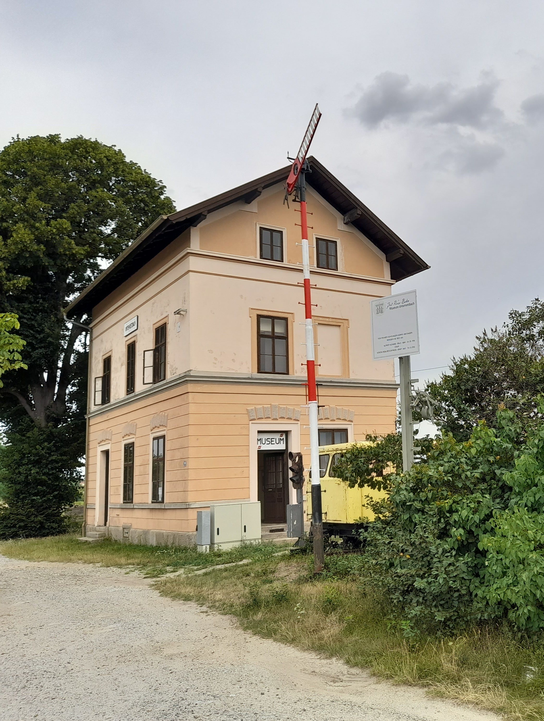 Old station building with museum sign and signal in Unter-Retzbach.