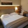 Cozy hotel room with double bed, wooden furniture and wall decoration.