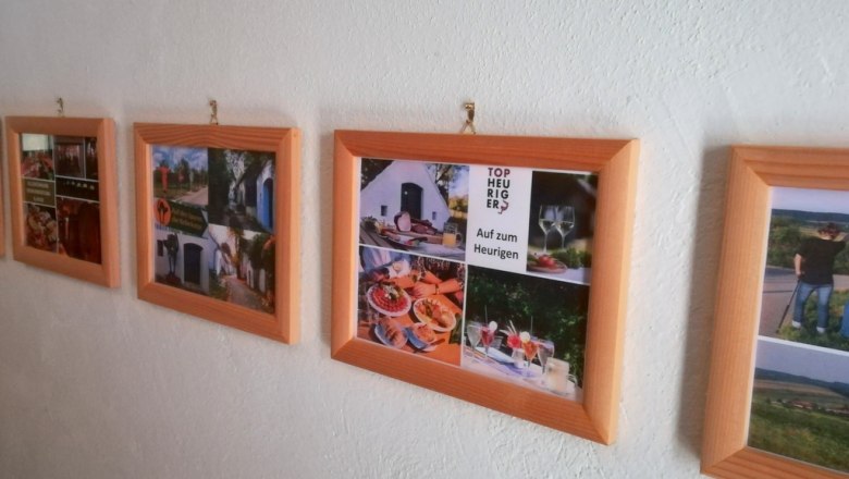 A row of picture frames with photos on a white wall.