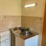 Small kitchenette with sink, stove and fridge.
