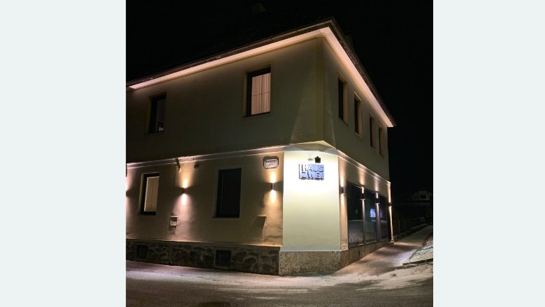 Building illuminated at night with the inscription 'Haus Zwei'.