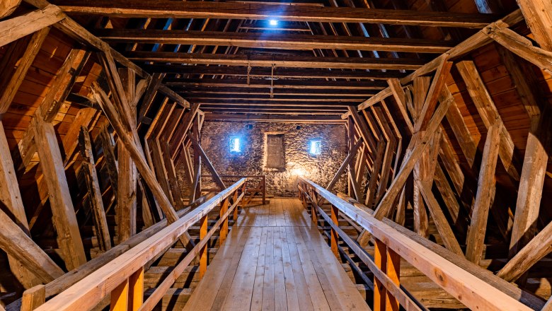 Interior view of the upper floor of the Lichtenegg fortified church with wooden beams and stone fa&ccedil;ade.