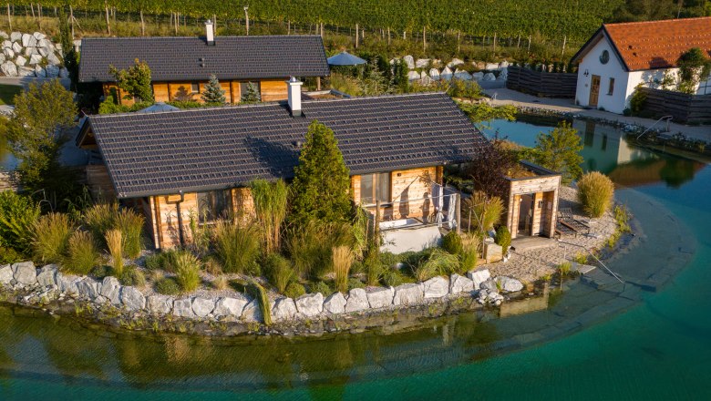 Kittenberger Chalets at the Gartensee, © Niederösterreich Werbung / Maximilian Pawlikowsky Aerial view of chalets on the garden lake with jetty and deckchair.