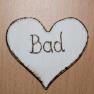 Wooden sign in the shape of a heart with the inscription 'Bad'.