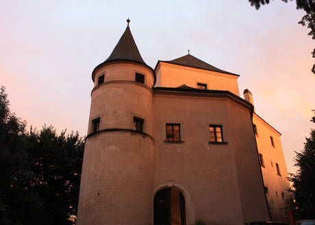 Wildegg Castle at sunset with illuminated towers and windows.