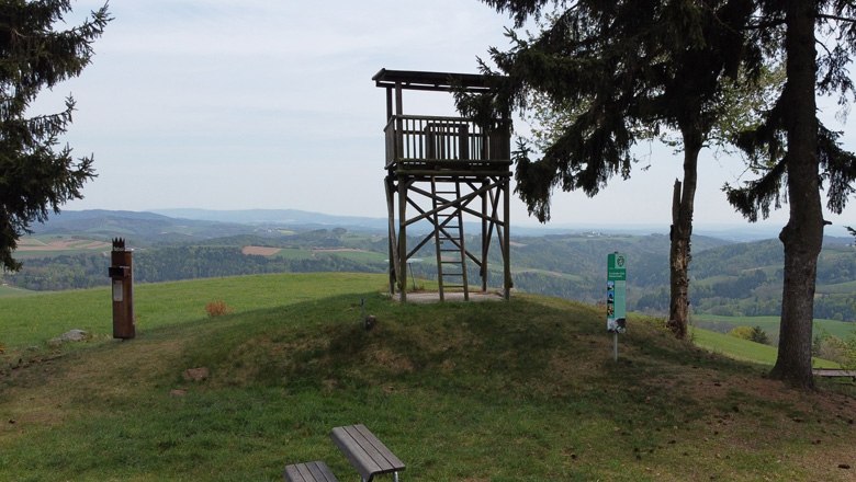 Viewing platform on a hill overlooking a hilly landscape.