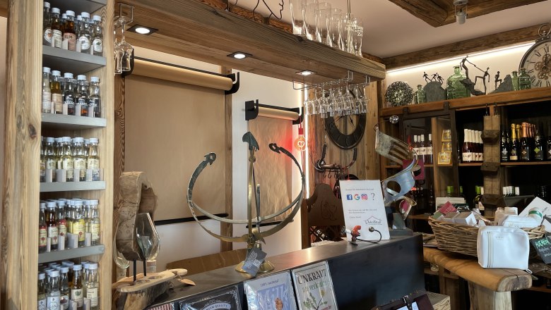 Interior view of a rustic store with spirits, glasses and decorative items.