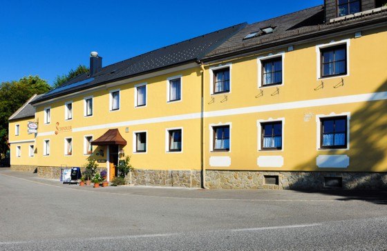 Yellow building with several windows and an entrance, labeled Gasthof Schindler.