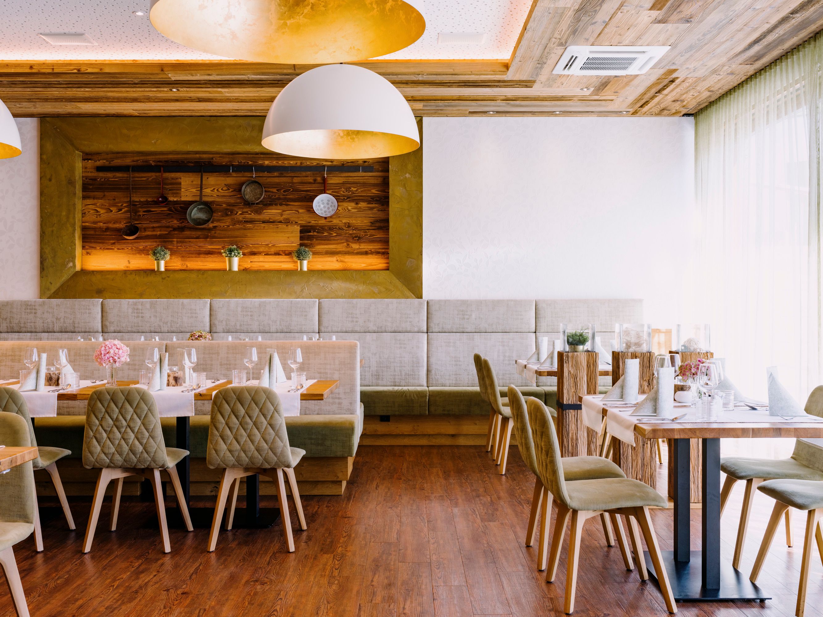 Modern restaurant with wooden elements and elegant table decorations.