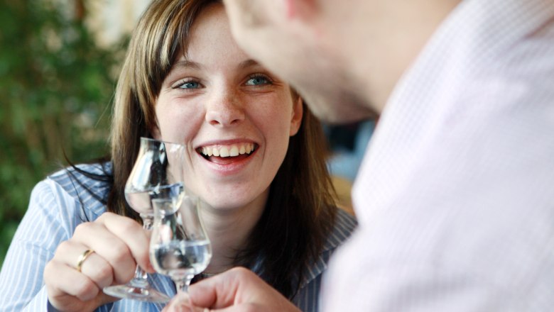 Two people clink glasses and smile.