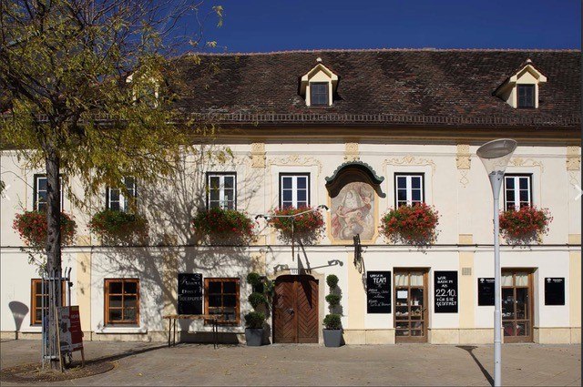 Historic building with flower boxes and murals.