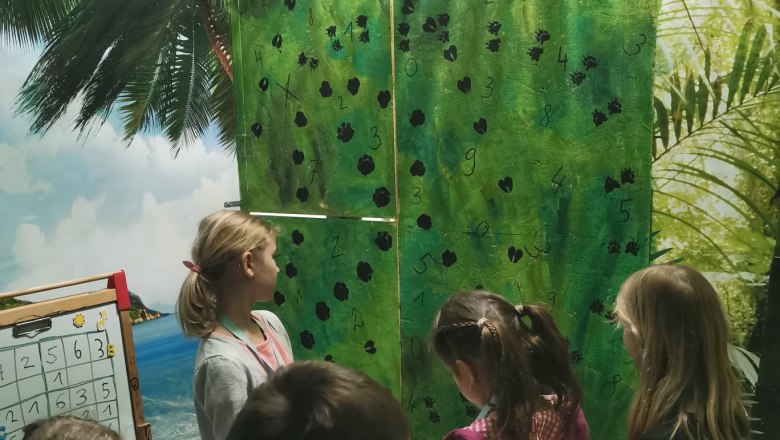 Children stand in the room and read a riddle