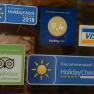 Stickers from HolidayCheck, Booking.com, TripAdvisor and Visa on a glass surface.