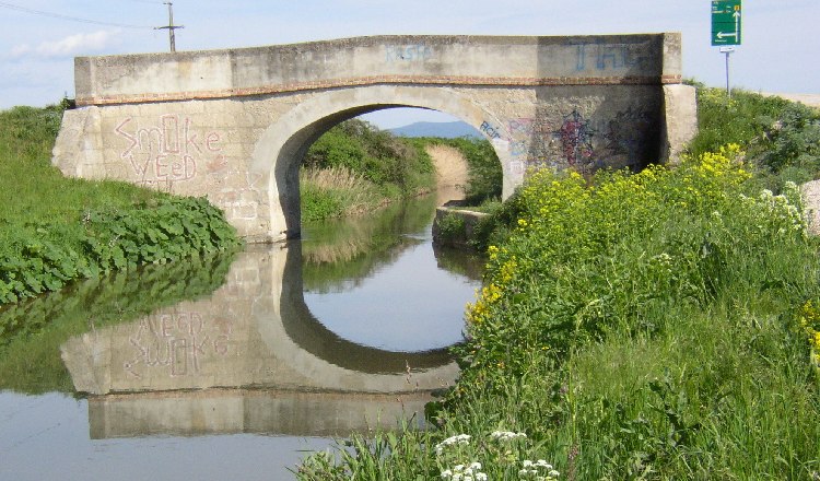 Bridge over the Wiener Neust&auml;dter Canal in Eggendorf with graffiti and reflection in the water.