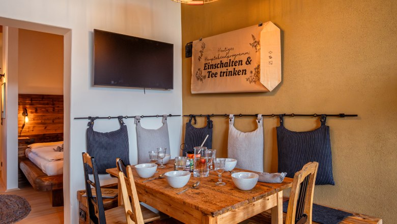 Cozy dining area with wooden table, chairs and decorative lamp in an apartment.