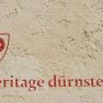 Wall with red lettering 'heritage dürnstein' and a red symbol.