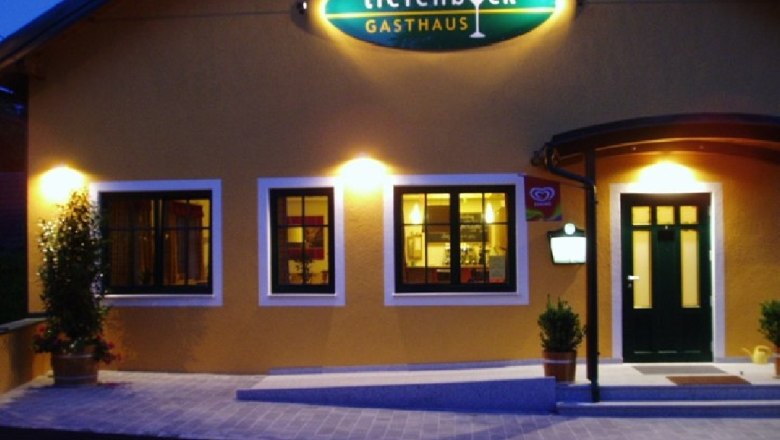 Exterior view of an inn with illuminated sign 'Tiefenböck'.