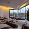 Interior view of a modern relaxation room with loungers and large windows with a view of nature.