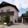 Straßenansicht des Hauses mit gepflegtem Vorgarten und Einfahrt mit Garage.