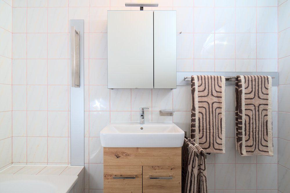 Modern bathroom with washbasin, mirror and towels.