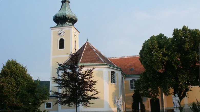 Wolfsthal pilgrimage church with tower and statues in the foreground.