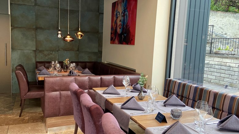 Elegant restaurant with covered tables and large windows.