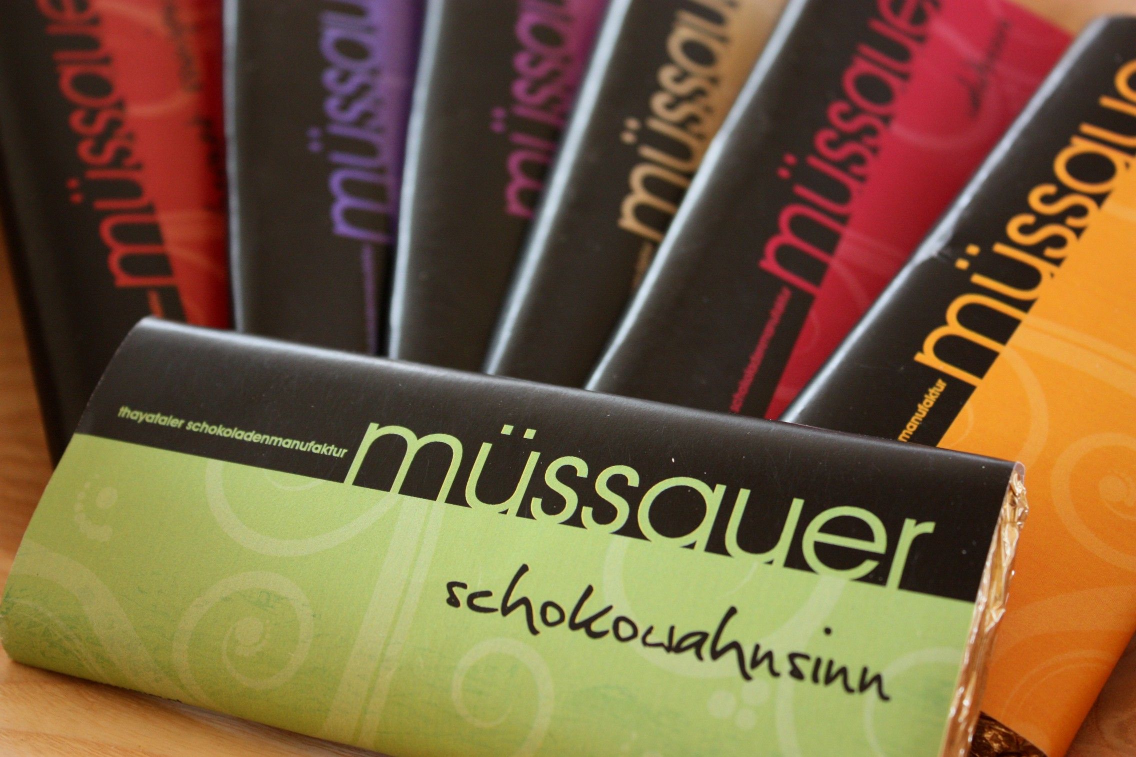 Various Müssauer brand chocolate bars in colorful packaging.
